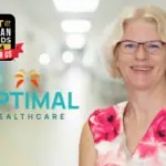 A woman in a floral blouse stands next to a logo for Optimal Healthcare, with a "Best of Cayman Islands 2024" badge above. Dr. Watkin, nominated Best Paediatrician, celebrates alongside.