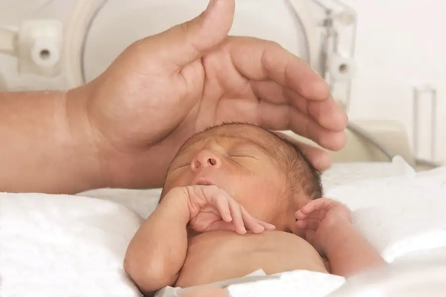 Baby receiving neonatal care in an incubator