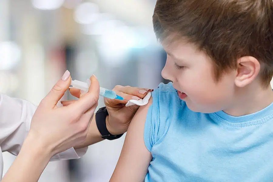 Boy receiving immunisation as part of a schedule