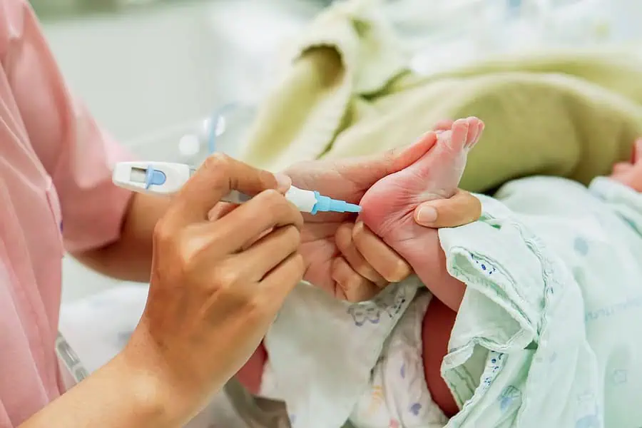 Conducting a baby check on a newborn