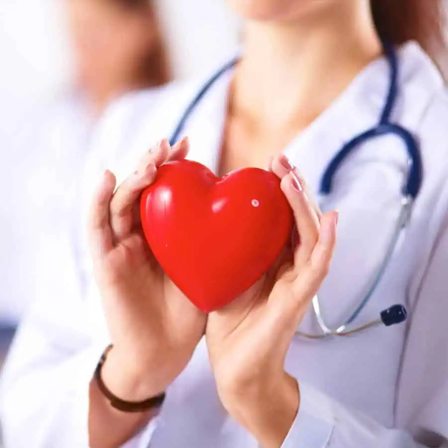 A medical professional in a white coat holds a red heart-shaped object, symbolizing the heart of Optimal Healthcare