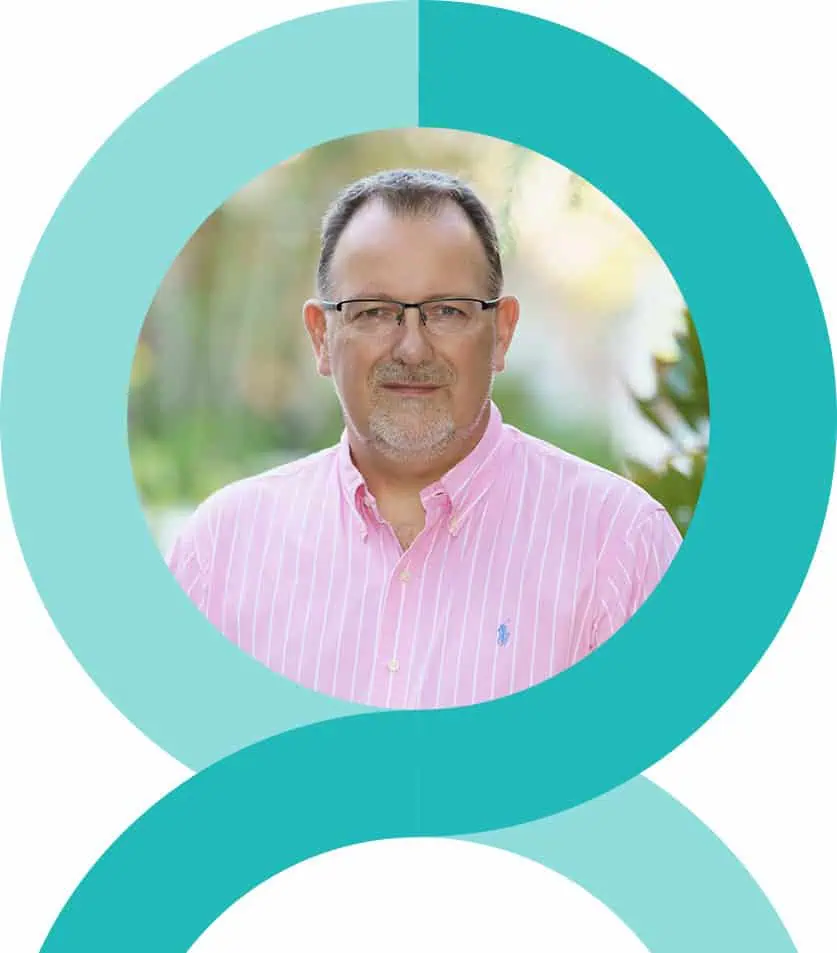 Man in pink striped shirt and glasses, standing outdoors with blurred greenery in the background, framed by blue-green circular graphics.